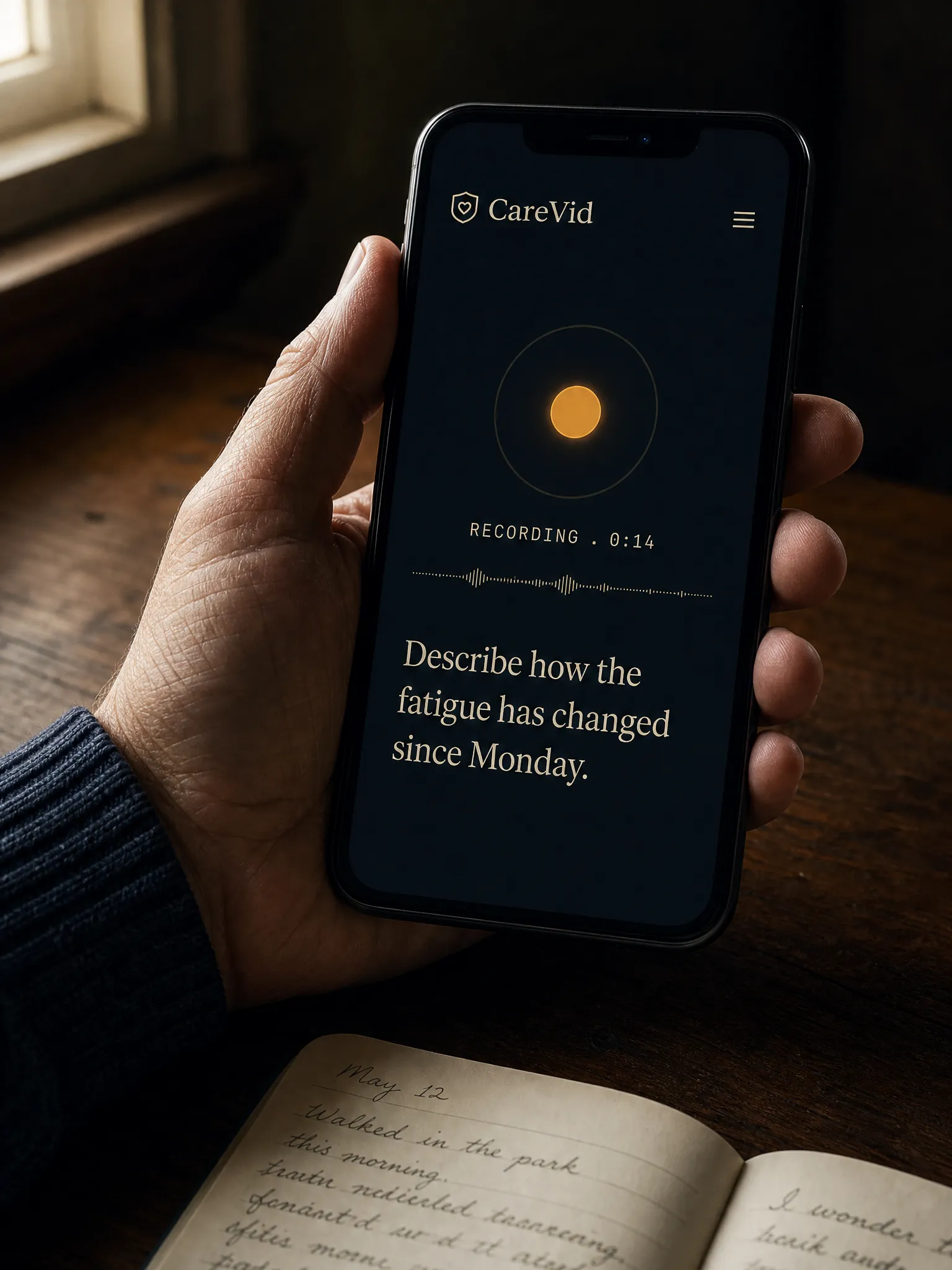 Editorial portrait of a hand holding a phone showing the CareVid recording interface in soft window light