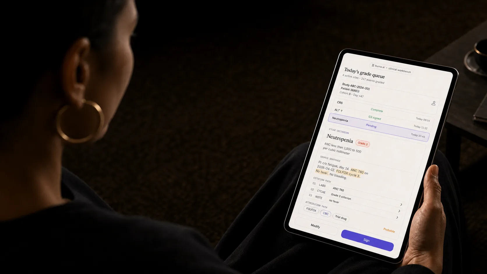Editorial photo of a woman doctor holding the ctcae grading tablet app.